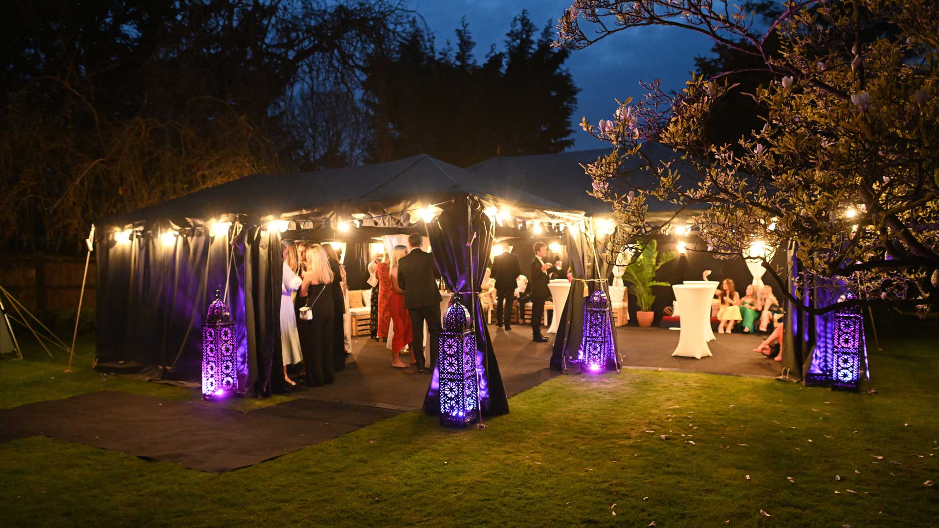 Black Tie Event Inside a Starcloth Lined Tent with lots of colourful lighting.