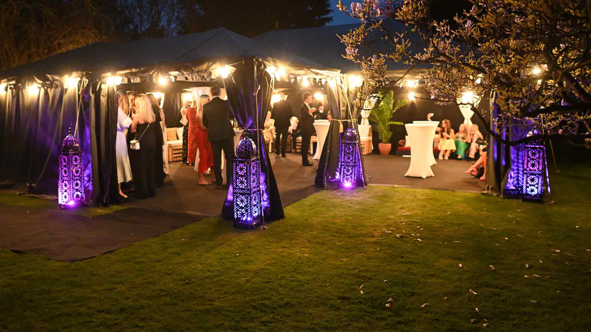 Large Colorful Moroccan Candle Lanterns Lit with Purple RGB Uplighters Outside a Boutique Black-Tie Event Marquee