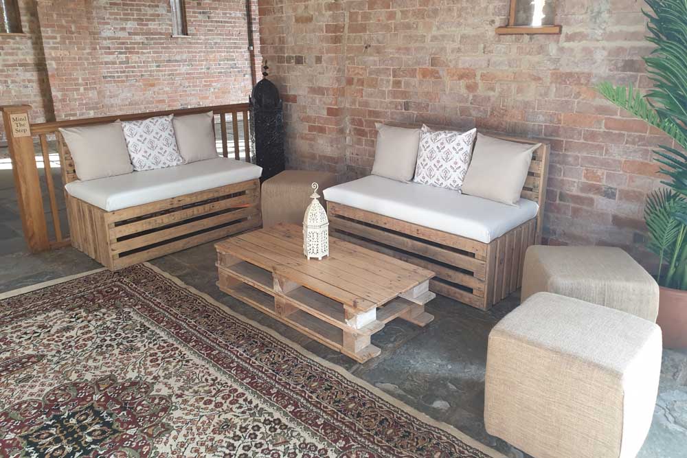 Pallet Benches, Tables, Hessian Cubes, Palm Tree, and Persian Rugs at Mickleton Hills Farm Wedding Venue